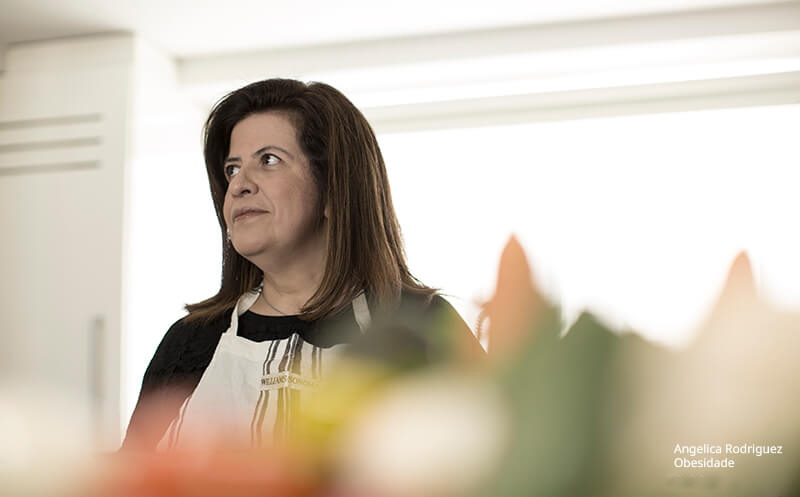 Mulher usando avental branco em ambiente interno, olhando para o lado