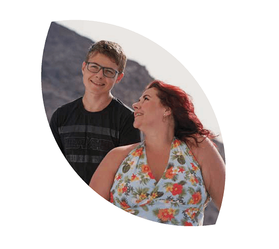 mãe sorrindo e olhando para o filho que está ao lado