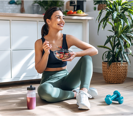 mulher sorrindo segurando um prato de salada